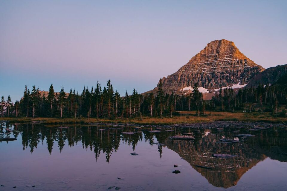 A mountain reflected in still water at dusk